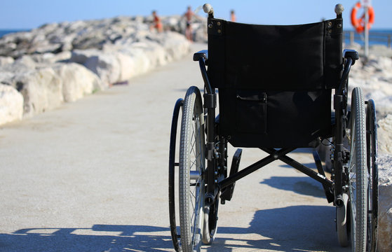 wheelchair from behind near the shore of the sea