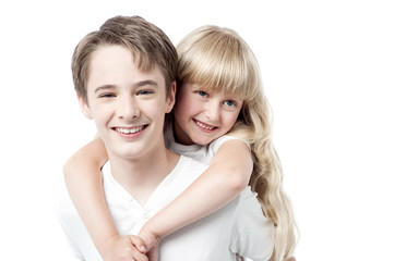 Young boy giving little girl piggyback ride