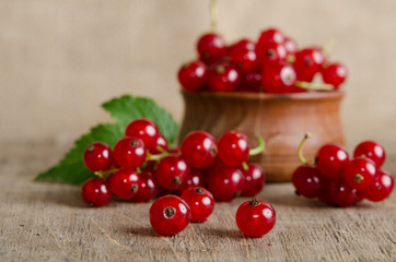 Red currant in wooden plate on the table