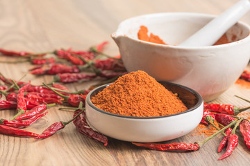 red hot pepper chili powder in a mortar and pods