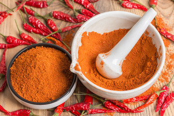 red hot pepper chili powder in a mortar and pods