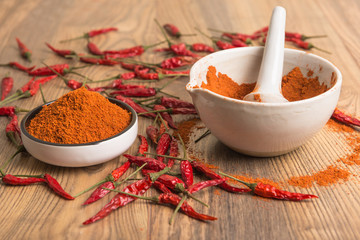 red hot pepper chili powder in a mortar and pods