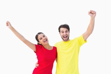 Excited couple cheering in red and yellow tshirts