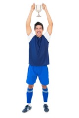 Football player in blue holding winners cup