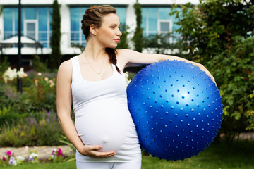 Naklejka premium Beautiful pregnant woman relaxing in the park