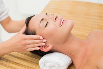 Fototapeta na wymiar Smiling brunette enjoying a head massage