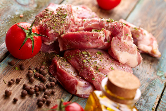 Raw steak with tomatoes over wooden background