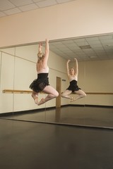 Beautiful ballerina dancing in front of mirror