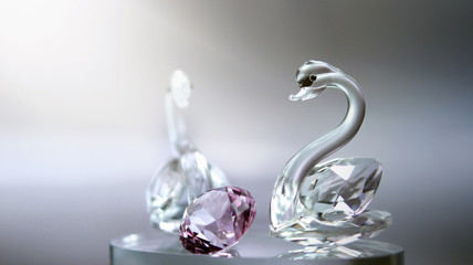 Crystal glass swans with a pink diamond