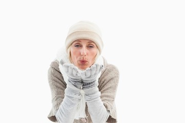 Mature woman in winter clothes blowing kiss