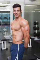 Fototapeta na wymiar Shirtless muscular man posing in gym