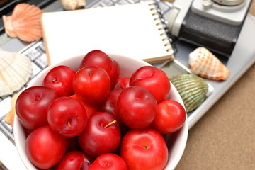 Naklejka na ściany i meble Laptop, shells, red plums and notebook