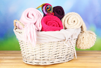 Warm knitted scarves in basket