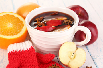 Fragrant mulled wine in bowl on wooden table close-up