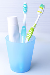 Toothbrushes in glass on table on light background © Africa Studio