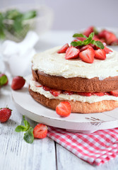 Delicious biscuit cake with strawberries on table close-up