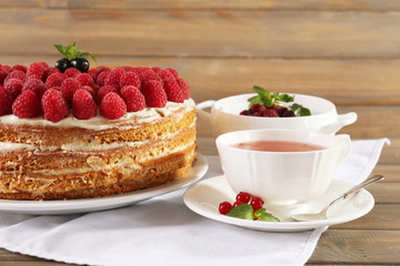 Tasty cake with fresh berries on wooden table