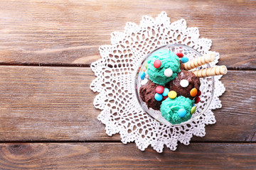 Chocolate ice cream with multicolor candies and wafer rolls in