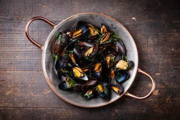 Tuinposter Boiled mussels in copper cooking dish on dark wooden background © Natalia Lisovskaya