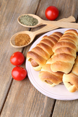 Baked sausage rolls on plate on table close-up