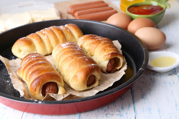 Baked sausage rolls in pan on table close-up