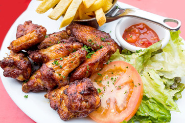 Chicken wings with sauce and golden French fries