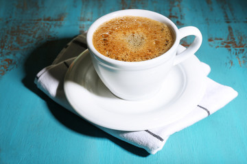 Cup of coffee on color wooden background