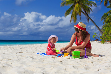 mother and daughter playing on tropical beach