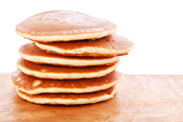 Stack of pancakes on wooden board with white background