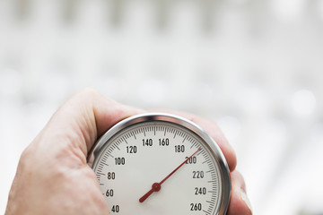 Mann haltet Blutdruckme&szlig;ger&auml;t im hand