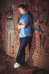 Man leaning on a brick wal