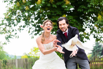 Brautpaar mit fliegenden weißen Tauben