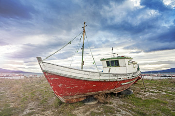 Fototapeta premium Old boat on a beach at sunset, Patagonia, Chile