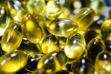 fish oil pills closeup on black plate macro