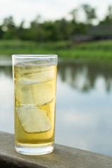 A Glass of beer with ice beside thailand river