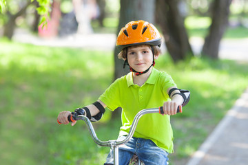 Kid rides a bicycle in city park