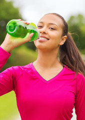 smiling woman drinking from bottle