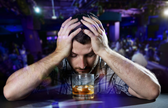 alcoholic drunk man on alcohol addiction at disco nightclub