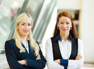 Portrait of two confident happy corporate business women