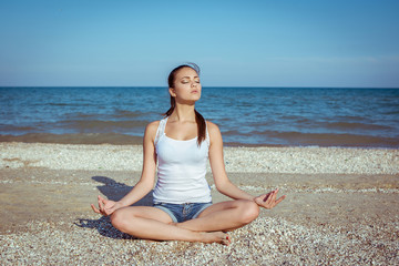 Fototapeta na wymiar young woman practicing yoga or fitness at seashore