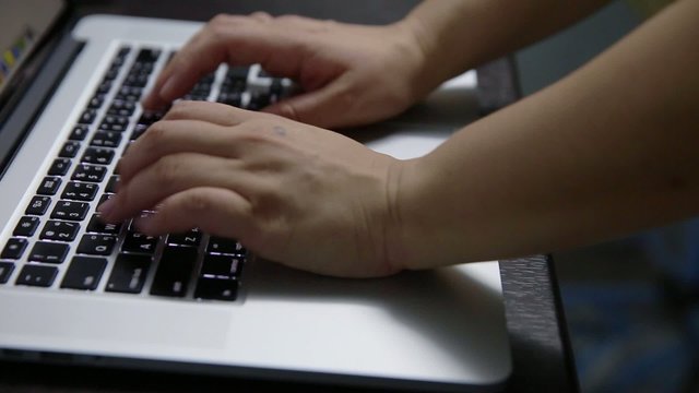 hand typing laptop in the dark
