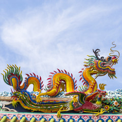 Fototapeta na wymiar Chinese dragon on blue sky with cloud top of temple