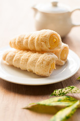 Cream-filled pastry roll on the wood board