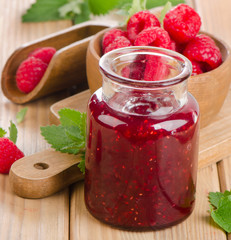 Glass jar of jam with fresh raspberries