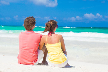 Fototapeta premium happy young couple sitting at beach
