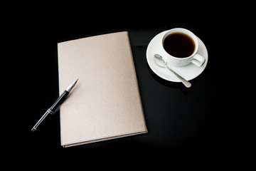 close notebook, pen and cup of coffee