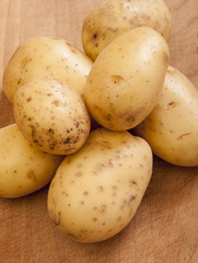 Potatoes on wooden background close up