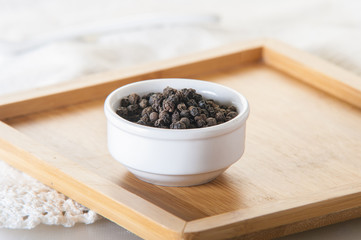 Black pepper on wood background