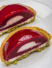 Cut strawberry tart on white background