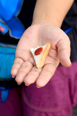 Sandwich bread topped with strawberry jam on hand.